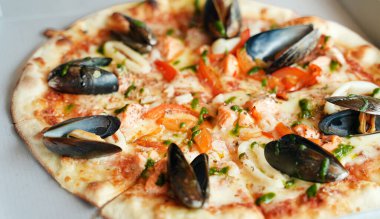 Midyeli, kalamarlı ve karidesli çıtır deniz ürünleri pizzası..