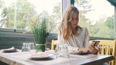 Bir restoranda sipariş bekleyen ergen bir kız..