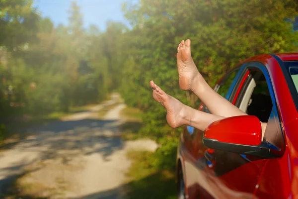 女人的腿伸出车窗外 无忧无虑的滑稽旅行的概念 — 图库照片
