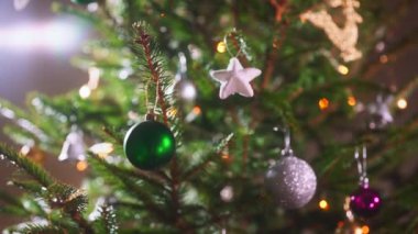 Toplar ve çelenklerle süslenmiş Noel ağacı.