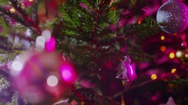 Toplar ve çelenklerle süslenmiş Noel ağacı.