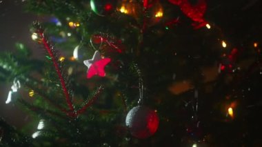 Toplar ve çelenklerle süslenmiş Noel ağacı.
