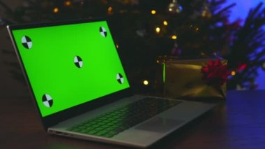 Yılbaşı ağacı ve hediyeli dizüstü bilgisayar. Reklamınız için yeşil krom anahtar.