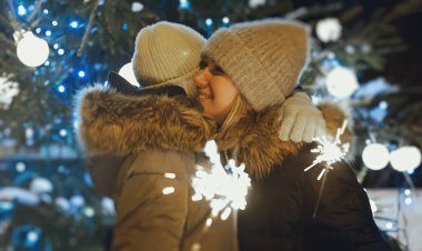 Bengal ateşi olan aile Noel ağacının yanında sarılıyor..