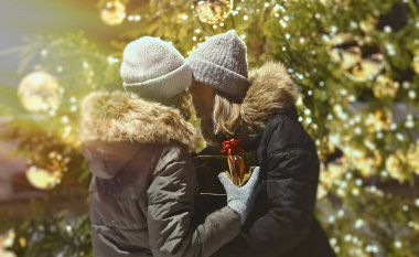 Anne ve kızı Noel hediyeleriyle ağacın altında..