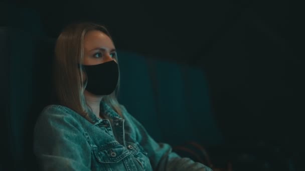 Γυναίκα Ιατρική Μάσκα Βλέπει Ταινία Στον Κινηματογράφο — Αρχείο Βίντεο