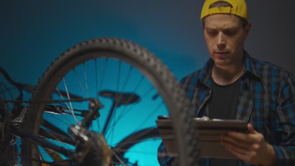 Man Calculates Price Repairing Bike — Vídeo de Stock