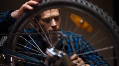 Technician examines wheel of the bicycle. Bicycle repair workshop.