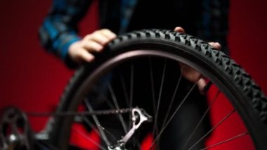 Technician examines wheel of the bicycle. Bicycle repair workshop.