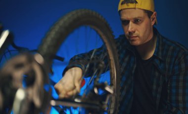Technician calibrates the wheel of the bicycle. Bicycle repair workshop.