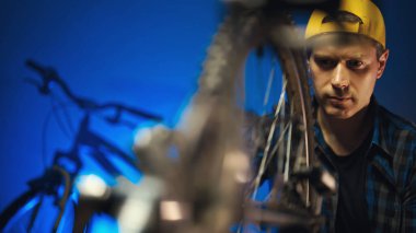 Technician calibrates the wheel of the bicycle. Bicycle repair workshop.