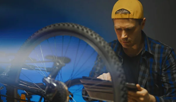 Master Tablet Examines Wheel Bicycle Bicycle Repair Workshop — Zdjęcie stockowe