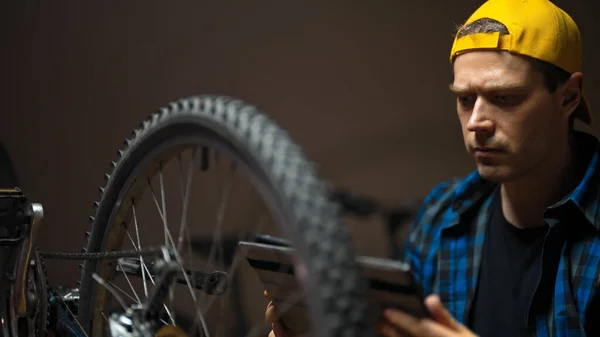 Master Tablet Examines Wheel Bicycle Bicycle Repair Workshop — Zdjęcie stockowe