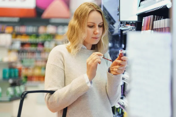 化粧品店で化粧品を試す女性 — ストック写真