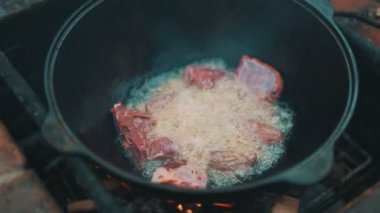 Et kazanda ateşte pişiyor. Pilaf 'ın aşçılığı adım adım.