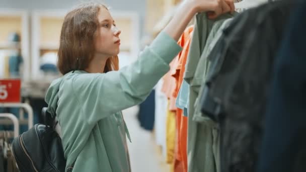 Adolescente Menina Escolhendo Roupas Shopping — Vídeo de Stock