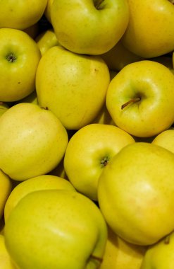 Süpermarkette sarı elma yığını.