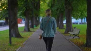 Yeşil bir yaz geçidinde dans eden mutlu kadın.