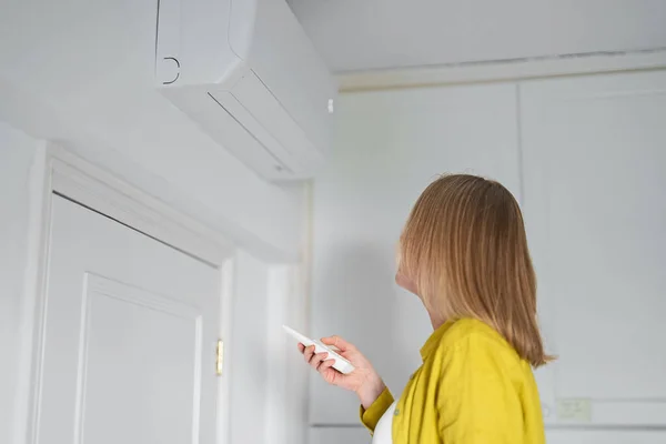 Vrouw Met Afstandsbediening Gericht Air Conditioner — Stockfoto