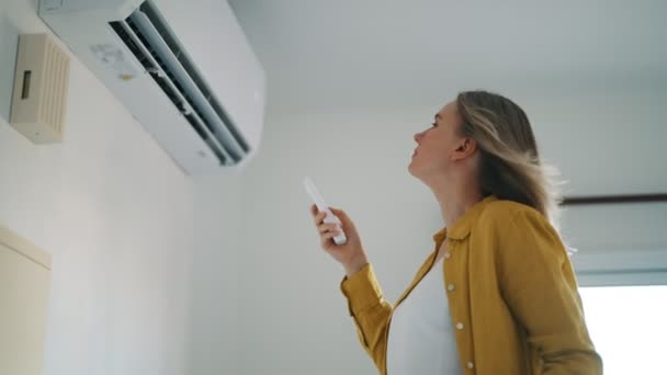 Vrouw Met Afstandsbediening Gericht Air Conditioner — Stockvideo