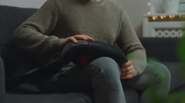 Adam bacağına elektrikli ayak masajı yapıyor..