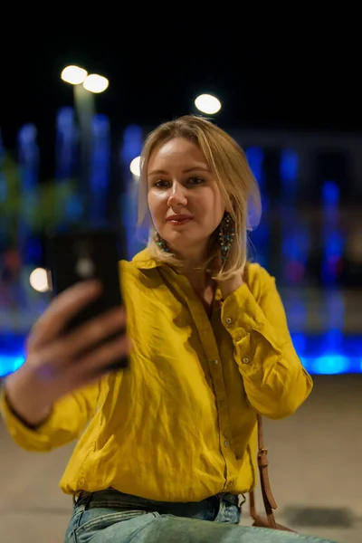 Γυναίκα Βγάζει Selfie Μπροστά Από Σιντριβάνι Βράδυ — Φωτογραφία Αρχείου