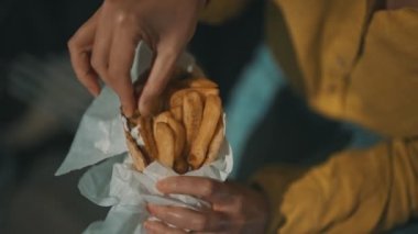 Klasik Yunan pidesi ve patates kızartması yiyen bir kadın..