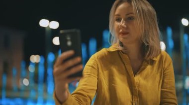 Akıllı telefonlu bir kadın tatilde video görüşmesi yapıyor..