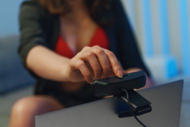 Kırmızı iç çamaşırlı bir kadın stüdyoda web kamerası modeli olarak çalışıyor..
