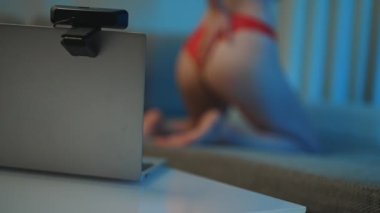 Kırmızı iç çamaşırlı bir kadın stüdyoda web kamerası modeli olarak çalışıyor..