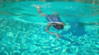 Mutlu kız yüzme havuzunda suya dalıyor. Tatil kavramı.