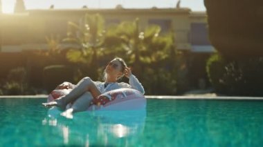 Tatilde havuzda dinlenen bir kadın..