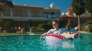 Tatilde havuzda dinlenen bir kadın..