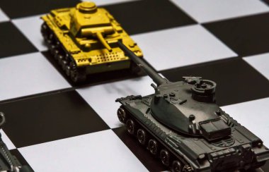 Satranç tahtasındaki oyuncak tanklar. Askeri strateji kavramı.
