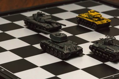 Satranç tahtasındaki oyuncak tanklar. Askeri strateji kavramı.