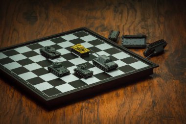 Satranç tahtasındaki oyuncak tanklar. Askeri strateji kavramı.