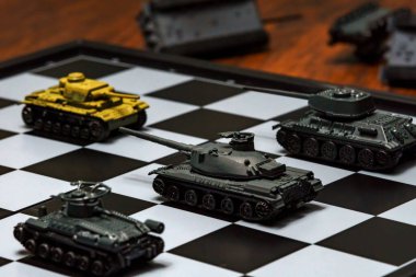 Satranç tahtasındaki oyuncak tanklar. Askeri strateji kavramı.