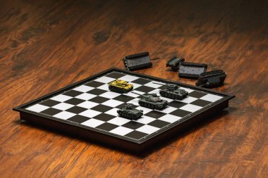Satranç tahtasındaki oyuncak tanklar. Askeri strateji kavramı.