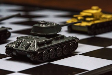 Satranç tahtasındaki oyuncak tanklar. Askeri strateji kavramı.