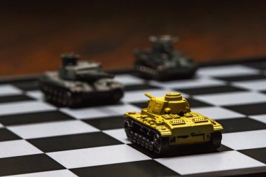 Satranç tahtasındaki oyuncak tanklar. Askeri strateji kavramı.