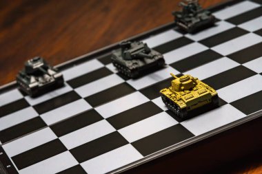 Satranç tahtasındaki oyuncak tanklar. Askeri strateji kavramı.