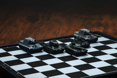 Satranç tahtasındaki oyuncak tanklar. Askeri strateji kavramı.