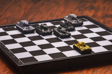 Satranç tahtasındaki oyuncak tanklar. Askeri strateji kavramı.