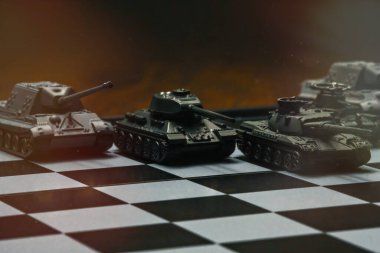 Satranç tahtasındaki oyuncak tanklar. Askeri strateji kavramı.
