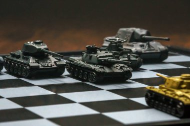 Satranç tahtasındaki oyuncak tanklar. Askeri strateji kavramı.