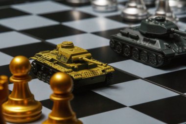Satranç tahtasında satranç oynayan oyuncak tanklar. Askeri strateji kavramı.
