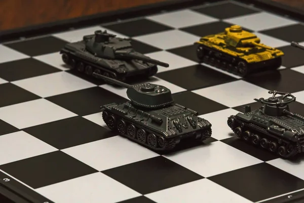 Satranç tahtasındaki oyuncak tanklar. Askeri strateji kavramı.