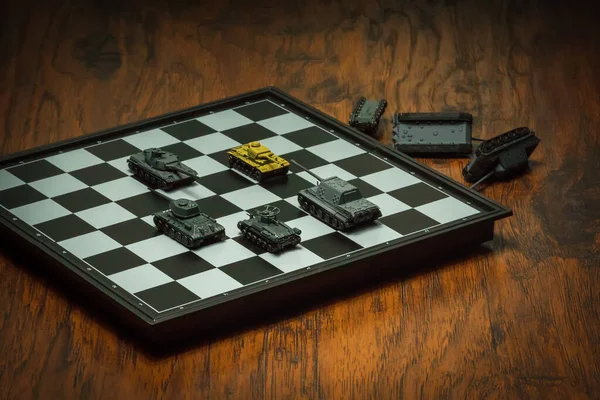 Satranç tahtasındaki oyuncak tanklar. Askeri strateji kavramı.