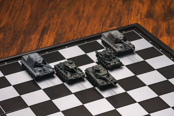 Satranç tahtasındaki oyuncak tanklar. Askeri strateji kavramı.