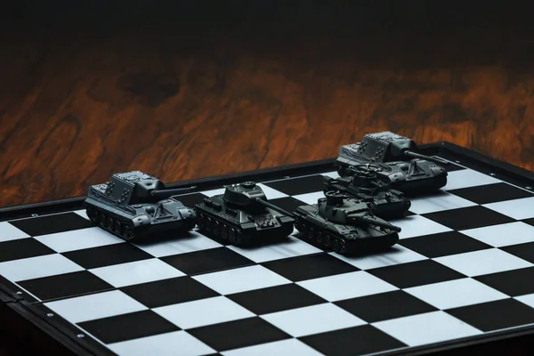 Satranç tahtasındaki oyuncak tanklar. Askeri strateji kavramı.